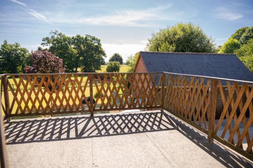 a wooden fence on a balcony with a house at Maison la touchardiere in Barenton