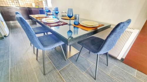 Luxury 2-bed apartment minutes to downtown في نيقوسيا: طاولة طعام مع كراسي زرقاء وطاولة زجاجية
