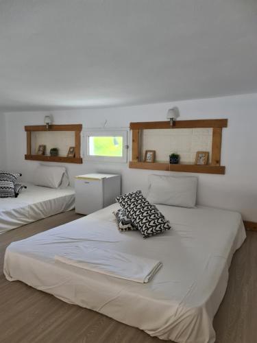 two beds in a room with white walls at Mar Adentro in Patitiri