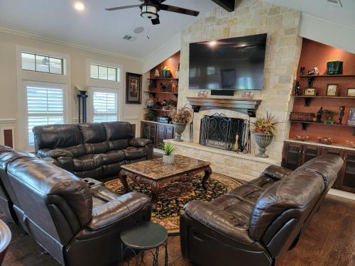 a living room with leather furniture and a fireplace at Newly Renovated Private Ranch Get-A-Way in Pilot Point