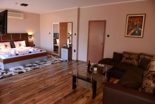 a living room with a bed and a couch at Family Hotel Gotse Delchev in Gotse Delchev
