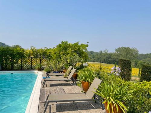 une rangée de chaises longues à côté d'une piscine dans l'établissement Les Jardins Haute Couture, à Huismes