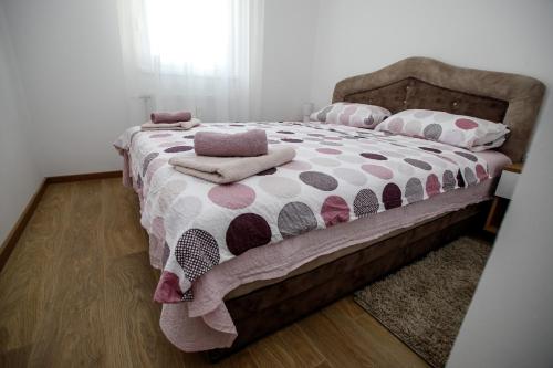 a bedroom with a bed with a polka dot blanket and pillows at Apartman Minja in Subotica
