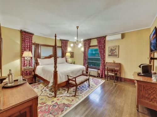 a bedroom with a bed and a desk and a television at Cartier Mansion in Ludington