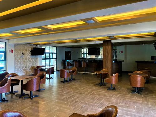 a lobby with chairs and tables and a bar at KAVIA MEOQUI HOTEL & SUITES in Meoqui