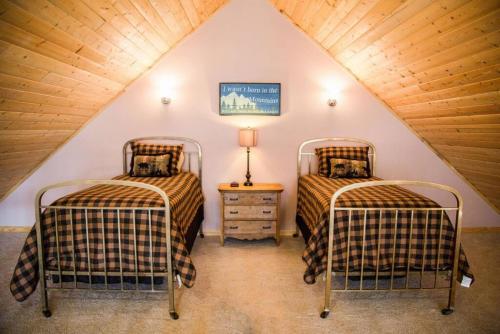 two beds in a room with a attic at Old Man Mountain, Spacious lodge with loft Great for families, Dogs allowed in Estes Park