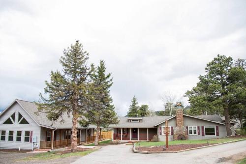 a white house with trees in front of it at Old Man Mountain, Spacious lodge with loft Great for families, Dogs allowed in Estes Park
