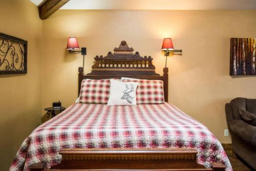 a bedroom with a bed with a red and white blanket at Sundance Suite, 1 Bedroom with fireplace Dogs OK in Estes Park