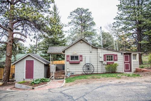 a white house with red doors and a driveway at Prospect Cabin, Cozy 1-bedroom cabin with kitchen Dogs OK in Estes Park