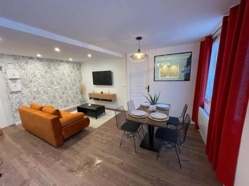a living room with a couch and a table and chairs at Le Jardin Niortais - Hyper centre- proche gare - Paisible - Grand Jardin privé, WIFI HD -NETFLIX in Niort