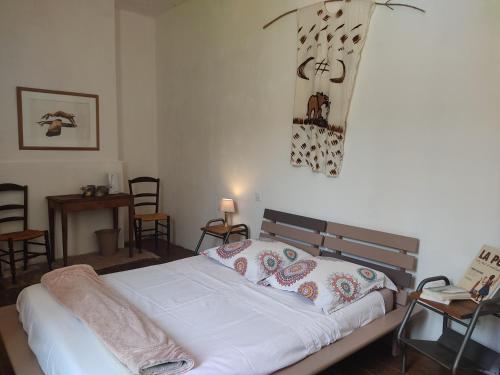 een slaapkamer met een wit bed met kussens erop bij La Bonheurie - Chambres chez l'habitant in Moissac