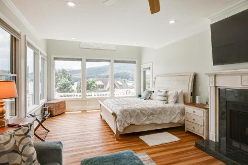 Dormitorio blanco con cama y chimenea en Roses Casa Del Largo Roses Lakehouse, en Hiawassee