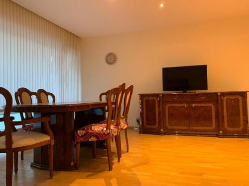 una sala da pranzo con tavolo, sedie e televisione di lovely two bedroom apartment with free parking ad Anversa