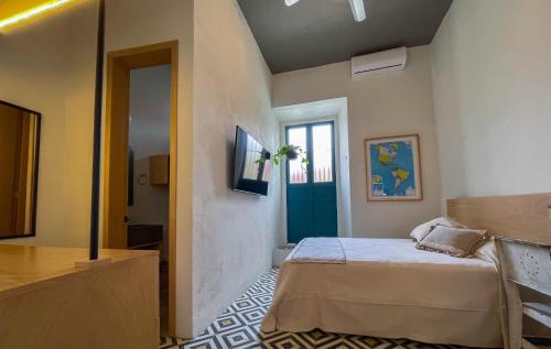 a bedroom with a bed and a blue door at Casa Blanco by Barrio Mexico in Guadalajara