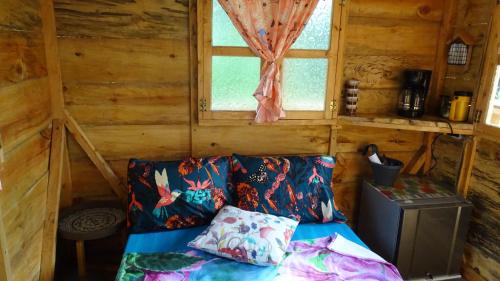 Habitación con sofá en una cabaña con ventana en Aventura Treehouse Glamping, en Palmira