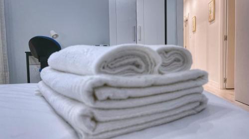 stos ręczników siedzących na łóżku w obiekcie VT Flat Reformado con Escritorio de Trabajo y Wifi w mieście Bilbao
