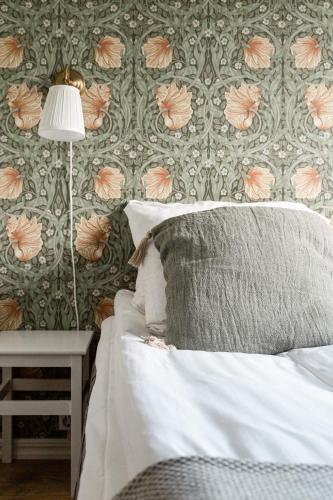 a bedroom with a bed and a wall with flowers at Hotell Åre Fjällsätra in Undersåker