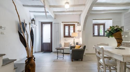 a living room with white walls and a table and chairs at Eleganza in Centro sul Lago - Anguillara Sabazia in Anguillara Sabazia