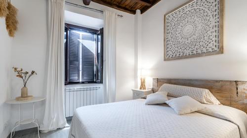 a white bedroom with a bed and a window at Eleganza in Centro Storico - Adelina in Anguillara Sabazia
