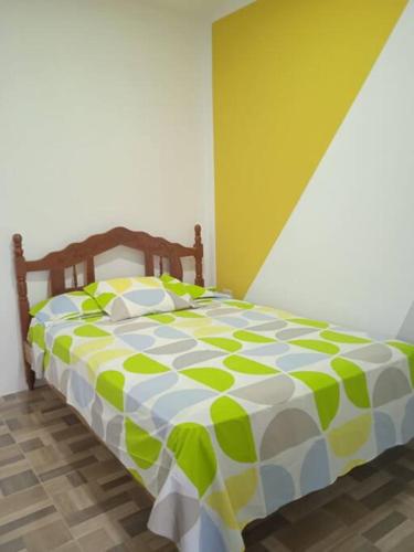 a green and white bed in a room at Departamento cómodo vacacional in Manta