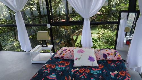 - une chambre avec un lit et une grande fenêtre dans l'établissement Cristal House Glamping at Villa Migelita Ecolodge, à Palmira