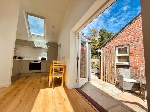 a kitchen with a table and a large window at The Garden House in Penzance