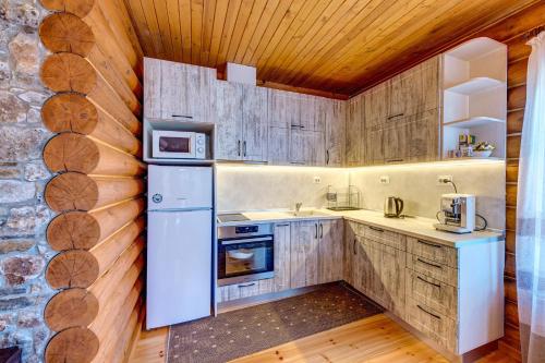 a kitchen with white appliances and wooden walls at Вила Морава in Pamporovo