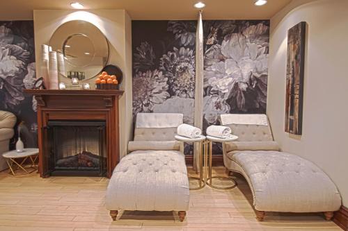 a room with two chairs and a mirror and a fireplace at Prince of Wales in Niagara on the Lake