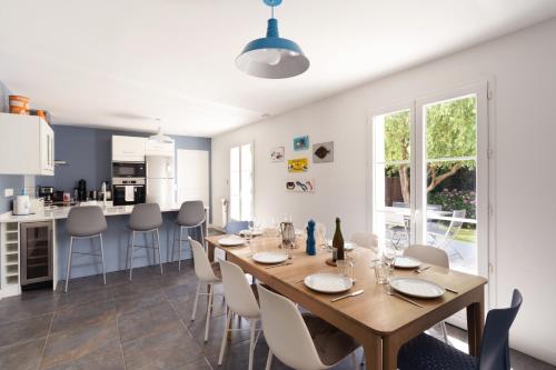 - une salle à manger et une cuisine avec une table et des chaises en bois dans l'établissement Villa du Littoral, à Villers-sur-Mer
