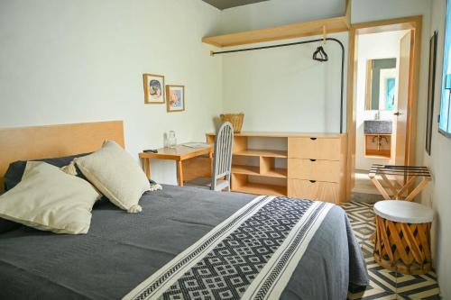 a bedroom with a bed and a desk and a table at Casa Blanco by Barrio Mexico in Guadalajara