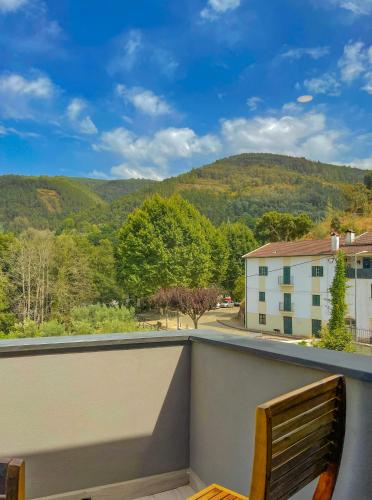 a balcony with a bench and a view of the mountains at Casa de Campo Vale do Ceira in Góis