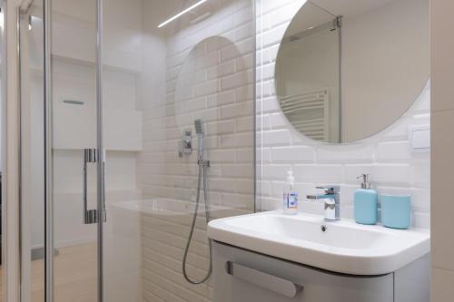 y baño blanco con lavabo y ducha. en Apartament Rodzinny Zielona, en Krynica-Zdrój