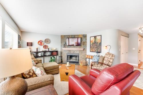 sala de estar con sofá de cuero rojo y chimenea en Park Pointe Markias Hideaway D102, en Chelan