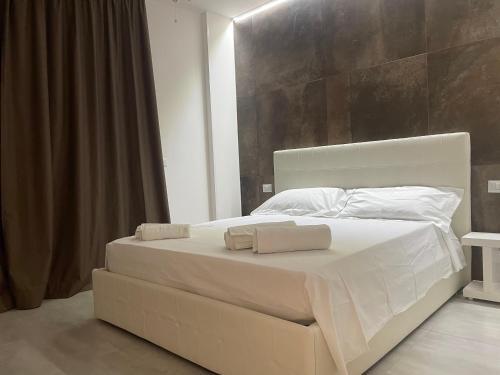 1 cama blanca grande con 2 toallas en Appartamento suite Anfitrite, en Pozzallo