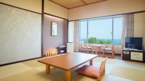 a living room with a table and chairs and a television at ANA Holiday Inn Resort Miyazaki by IHG in Miyazaki
