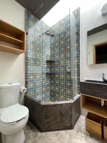 a bathroom with a toilet and a shower at Casa Blanco by Barrio Mexico in Guadalajara