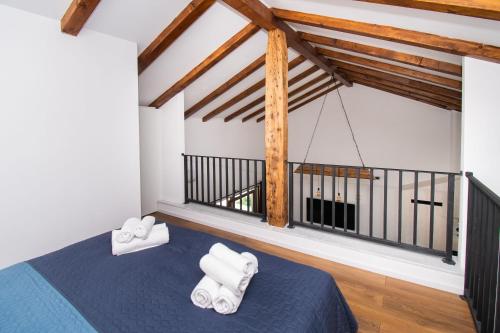 a bedroom with a blue bed and wooden beams at Villa Lucia in Skradin