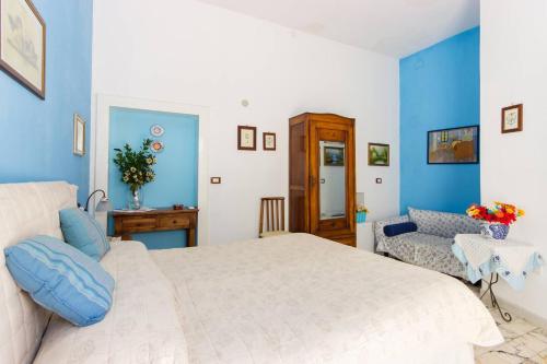 a bedroom with a white bed and a blue wall at L'Isola Di Ortigia in Siracusa