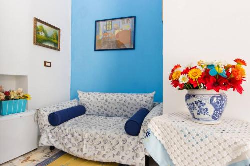 a living room with a couch and a vase of flowers on a table at L'Isola Di Ortigia in Siracusa