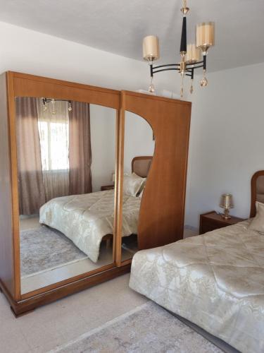 a bedroom with a mirror with a bed in it at Appartement carthage in Douar ech Chott