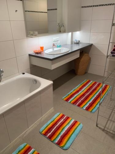 a bathroom with a tub and a sink and two rugs at Villa Pazelt Top4 in Bad Vöslau