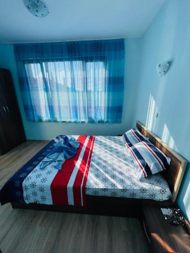 a bed in a bedroom with a blue wall at Kastela Guest House in Chernomorets