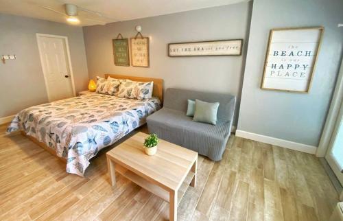 a bedroom with a bed and a chair and a table at Sea Dip Resort Studios! in Daytona Beach