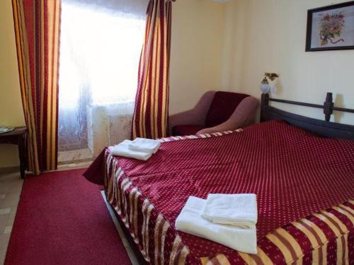 a bedroom with a red bed with towels on it at 100 metriv vid vytyagu in Bukovel