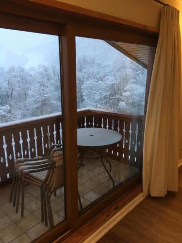 a balcony with a view of a snow covered forest at DEPARTAMENTOS TERMAS DE CHILLAN in Nevados de Chillan