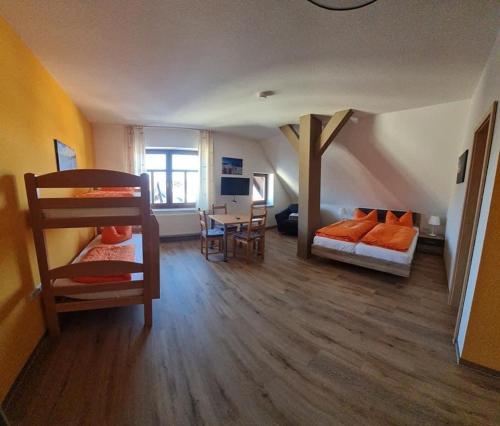 a room with two bunk beds and a living room at Wurzelrudis Hostel in Eibenstock
