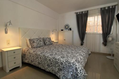 a bedroom with a bed and a dresser and a window at Agréable appartement au bord de l’ ocean, Playa Paraiso in Adeje
