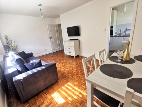 a living room with a couch and a table at Apartament Jaśminowy in Gdańsk