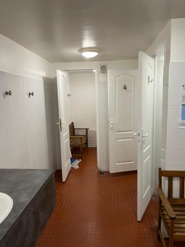 a bathroom with a sink and a toilet and two doors at Madi au fil de l'eau à Deauville in Deauville