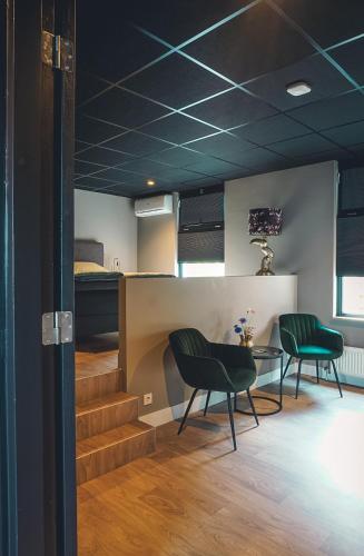 a room with two chairs and a table and a bed at B&Bie ons in Bad-Nieuweschans